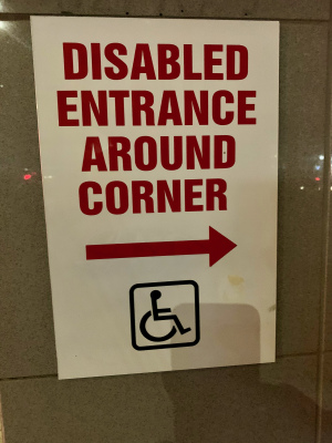 Disabled entrance around the corner sign